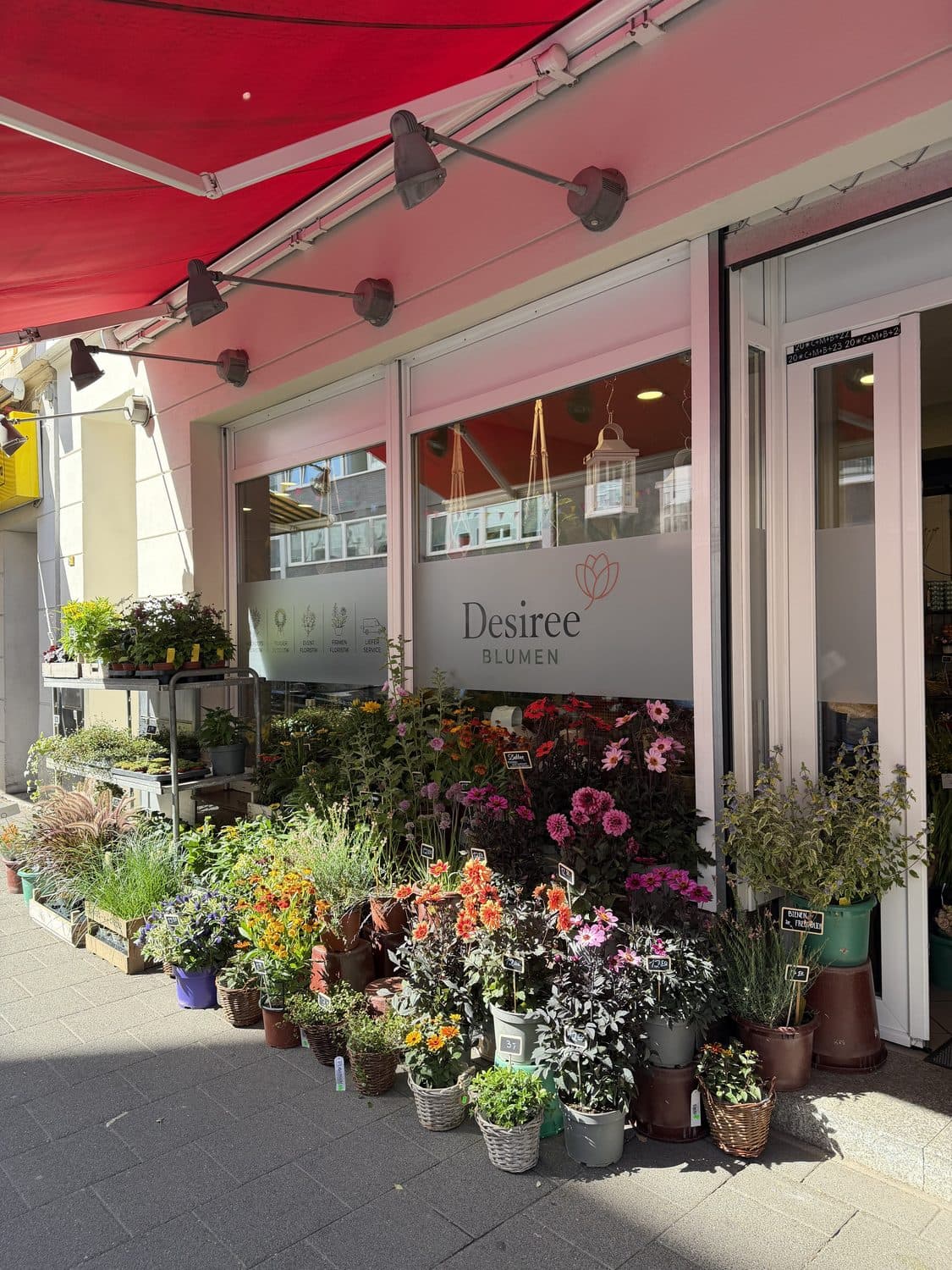 Ladenfront von Desiree Blumen mit Blumen und Pflanzen auf dem Gehweg